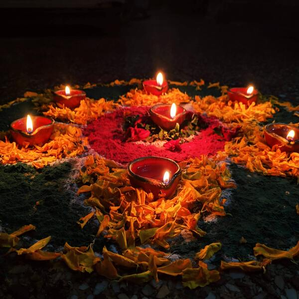 a lowlit image of candles lit and being used for Diwali celebrations